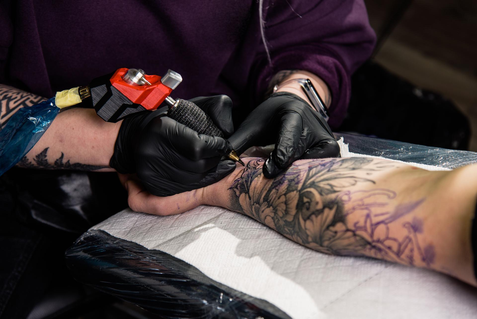 A tattoo artist makes a tattoo in a salon